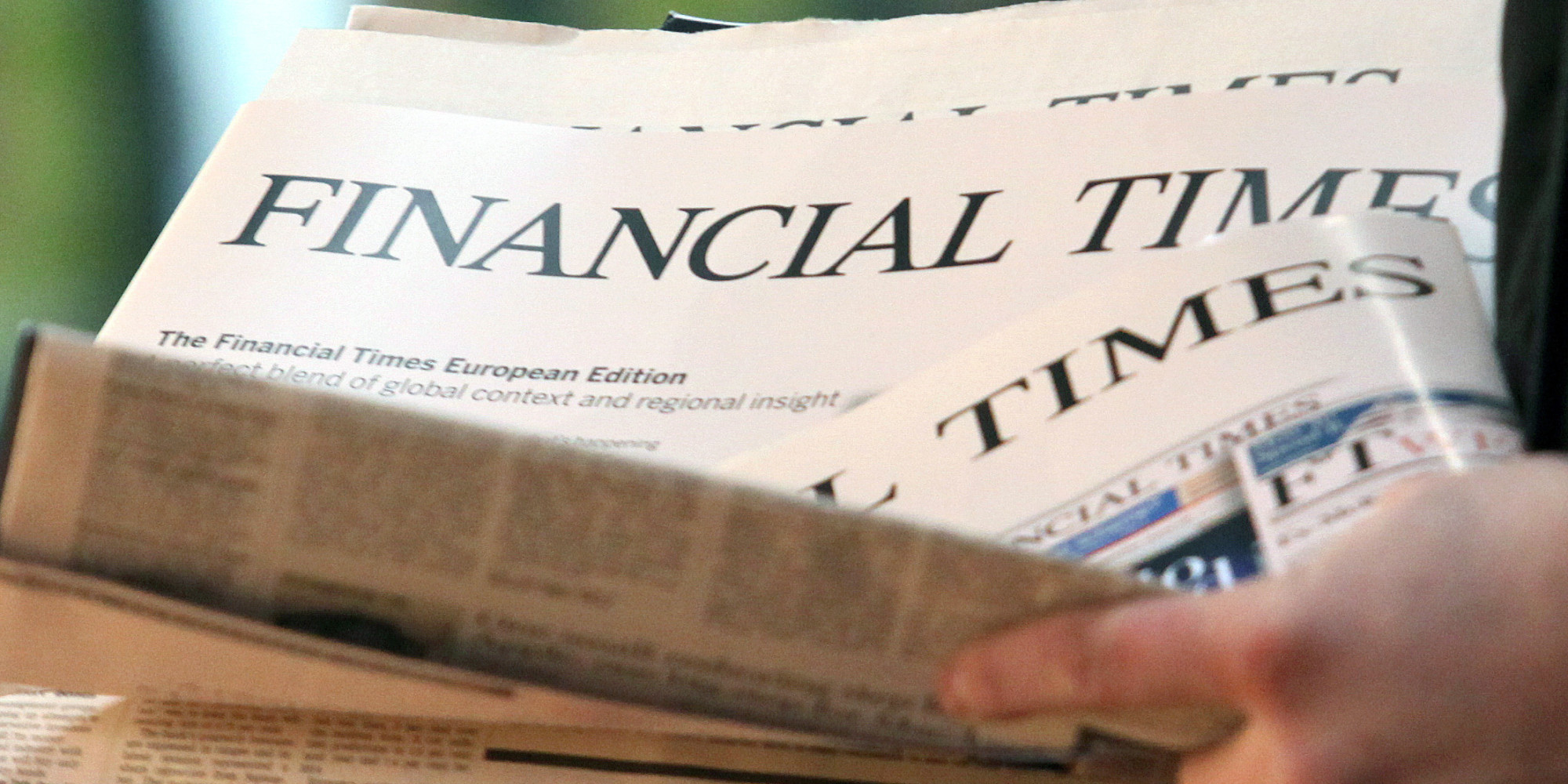 Copies of the English edition of the Financial Times are handed out at the central station in Hamburg, Germany, 07 December 2012. After 13 years, the FTD sells its final issue. Photo: Bodo Marks