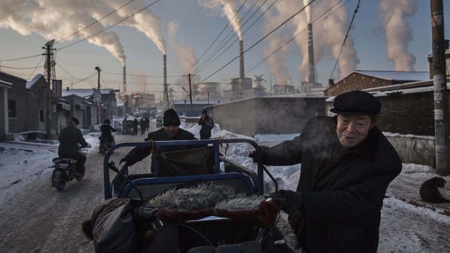 Primer premio en la categoría de vida diaria
© Kevin Frayer, Canada. Travajadores chinos tiran de un carro en una zona próxima a una planta térmica de carbón en Shanxi, China, el 26 de noviembre de 2015.