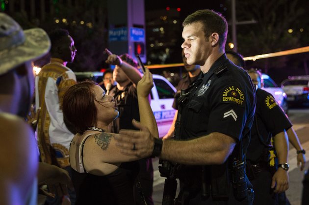 Police attempt to calm the crowd as someone is arrested following the sniper shooting in Dallas on July 7, 2016. 
A fourth police officer was killed and two suspected snipers were in custody after a protest late Thursday against police brutality in Dallas, authorities said. One suspect had turned himself in and another who was in a shootout with SWAT officers was also in custody, the Dallas Police Department tweeted.
 / AFP / Laura Buckman        (Photo credit should read LAURA BUCKMAN/AFP/Getty Images)
